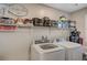 Organized laundry room with a washer, dryer, and ample shelving at 9327 S Chieftain St, Las Vegas, NV 89178