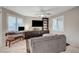 Cozy living room featuring large windows with plantation shutters, gray sofa, and entertainment center at 9327 S Chieftain St, Las Vegas, NV 89178