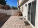 Private backyard with a brick paver patio, decorative pots, and a white fence creating a cozy outdoor space at 9333 Leaping Deer Pl # 103, Las Vegas, NV 89178