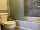 Modern bathroom featuring a toilet, bathtub with shower, glass shower screen, and tiled wall at 9333 Leaping Deer Pl # 103, Las Vegas, NV 89178