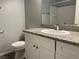 This bathroom features granite countertops, a white vanity, toilet, and updated flooring at 9333 Leaping Deer Pl # 103, Las Vegas, NV 89178