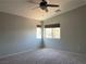 This bedroom features carpet, two windows with blinds, and a ceiling fan with a light at 9333 Leaping Deer Pl # 103, Las Vegas, NV 89178