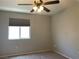 This bedroom features a ceiling fan, carpeted floor, and a window with blinds at 9333 Leaping Deer Pl # 103, Las Vegas, NV 89178