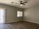 Spacious bedroom with wood-look flooring, ceiling fan, and access to a sliding glass door at 9333 Leaping Deer Pl # 103, Las Vegas, NV 89178