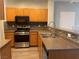 Kitchen showcasing stainless steel oven, sink, and microwave with oak cabinets at 9333 Leaping Deer Pl # 103, Las Vegas, NV 89178