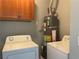 This laundry room includes a washer, dryer, water heater, and cabinet at 9333 Leaping Deer Pl # 103, Las Vegas, NV 89178