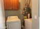 Convenient laundry room equipped with a washer, dryer, water heater, and overhead storage cabinets at 9333 Leaping Deer Pl # 103, Las Vegas, NV 89178