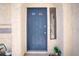 Exterior front door with blue paint, small side window, and textured stucco wall at 9552 Wooden Pier Way, Las Vegas, NV 89117