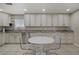 Bright kitchen with granite countertops, modern stainless steel appliances, and a central breakfast nook with transparent chairs at 9552 Wooden Pier Way, Las Vegas, NV 89117