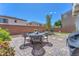 Cozy backyard patio area with dining furniture, greenery, and privacy wall at 9872 Chief Sky St, Las Vegas, NV 89178