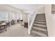 Comfortable living room with neutral tones, a staircase, and plenty of natural light at 9872 Chief Sky St, Las Vegas, NV 89178