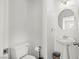 Bright bathroom with a pedestal sink, toilet, and neutral colored walls at 9962 Derby Creek Way, Las Vegas, NV 89148