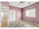 Neutral bedroom with wood-look floors, a ceiling fan, and double door closet at 9962 Derby Creek Way, Las Vegas, NV 89148
