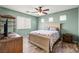Bedroom featuring a ceiling fan, wood laminate flooring, and green walls at 9962 Derby Creek Way, Las Vegas, NV 89148