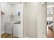 Laundry room with white washer and dryer and wire shelving for storage at 9962 Derby Creek Way, Las Vegas, NV 89148