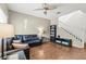 Inviting living room featuring hardwood floors, a dark sofa, and a ceiling fan at 9962 Derby Creek Way, Las Vegas, NV 89148