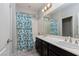 Bathroom featuring double sinks, and a shower/tub combination with floral curtain at 1015 Solana Crest St, Henderson, NV 89052