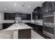 Modern kitchen features dark cabinets, stainless appliances, and granite countertops at 1015 Solana Crest St, Henderson, NV 89052