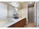 Bright bathroom featuring double sinks, a large mirror, and a separate shower room at 10370 Sweet Laurel St St, Las Vegas, NV 89178