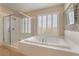 Bathroom featuring a shower, large soaking tub, and shuttered windows for natural light at 10370 Sweet Laurel St St, Las Vegas, NV 89178