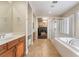 Bright bathroom featuring dual vanities, a walk-in shower, and a separate soaking tub at 10370 Sweet Laurel St St, Las Vegas, NV 89178