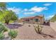 Desert landscaped backyard with patio, stone picnic table, and vibrant greenery at 10532 Sea Palms Ave, Las Vegas, NV 89134