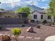 Serene backyard with mature desert landscaping, shrubbery, and views of the mountains at 10532 Sea Palms Ave, Las Vegas, NV 89134