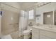 Well-lit bathroom featuring a tub with shower, vanity with countertop, and window with shutters at 10532 Sea Palms Ave, Las Vegas, NV 89134