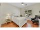 Cozy bedroom boasts a comfortable bed, a black leather chair, and a sunlit window at 10532 Sea Palms Ave, Las Vegas, NV 89134