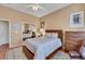 Cozy bedroom with neutral walls, a ceiling fan, a large mirror closet, and wood floors at 10532 Sea Palms Ave, Las Vegas, NV 89134