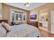 Bright bedroom featuring a large window, a wood dresser, a flat-screen TV, and ensuite bath access at 10532 Sea Palms Ave, Las Vegas, NV 89134