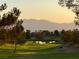 Scenic golf course view with a tranquil pond and mountain range in the background at sunset at 10532 Sea Palms Ave, Las Vegas, NV 89134