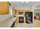 Kitchen features light-colored countertops, light wood cabinetry, black appliances, and tiled flooring at 10532 Sea Palms Ave, Las Vegas, NV 89134