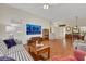 Spacious living room with hardwood floors, a plaid sofa, a flat-screen TV, and access to the dining area at 10532 Sea Palms Ave, Las Vegas, NV 89134