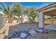 Spacious backyard featuring palm trees, rock landscaping, and covered patio for outdoor enjoyment at 10667 Casa Bianca St, Las Vegas, NV 89141