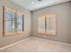 Cozy bedroom with tile flooring, neutral walls, and plantation shutters for ample natural light at 10667 Casa Bianca St, Las Vegas, NV 89141