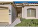 Close-up of the home's front entrance featuring desert landscaping, a tile roof, and a two-car garage at 10667 Casa Bianca St, Las Vegas, NV 89141