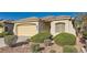 Inviting single-story home with a two-car garage, manicured bushes, and desert landscaping at 10667 Casa Bianca St, Las Vegas, NV 89141