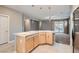 Well-lit kitchen with light wood cabinetry, stone countertops, and an open view to the living area at 10667 Casa Bianca St, Las Vegas, NV 89141