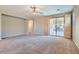 Large living room featuring carpet flooring, neutral walls, and a sliding glass door to the backyard at 10667 Casa Bianca St, Las Vegas, NV 89141