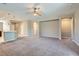 Expansive living room with carpet flooring, neutral walls, and an open layout to the kitchen at 10667 Casa Bianca St, Las Vegas, NV 89141