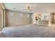 Open-concept living room with a view of the kitchen, carpet flooring, and natural light at 10667 Casa Bianca St, Las Vegas, NV 89141