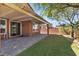 Landscaped backyard with artificial grass, patio, and covered area at 11014 Great Sioux Rd, Las Vegas, NV 89179