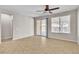 Neutral primary bedroom featuring tile floors, a ceiling fan, and a sliding glass door to the backyard at 11014 Great Sioux Rd, Las Vegas, NV 89179