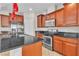 Kitchen with stainless steel appliances, granite countertops, modern lighting, and dark wood cabinetry at 11014 Great Sioux Rd, Las Vegas, NV 89179