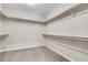 Spacious walk-in closet featuring wooden rods and neutral carpet at 11014 Great Sioux Rd, Las Vegas, NV 89179