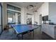 Spacious game room with a ping pong table, modern lighting fixtures, and ample natural light from large windows at 11256 Rainbow Peak Ave # 202, Las Vegas, NV 89135