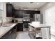 Modern kitchen with dark cabinets, stainless steel appliances, and a movable kitchen island at 11256 Rainbow Peak Ave # 202, Las Vegas, NV 89135