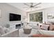 Open-concept living room with a modern entertainment system, ceiling fan, and lots of natural light at 11256 Rainbow Peak Ave # 202, Las Vegas, NV 89135