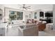 Open-concept living room with a ceiling fan, modern furniture, and lots of natural light from a large window at 11256 Rainbow Peak Ave # 202, Las Vegas, NV 89135